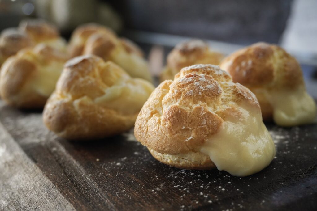 Bombas de crema sin gluten rellenas de crema pastelera sobre una tabla