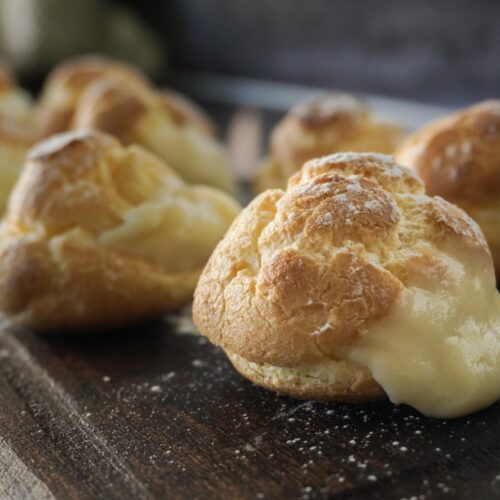 Bombas de crema sin gluten rellenas de crema pastelera sobre una tabla