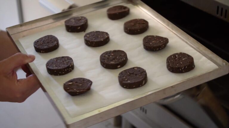 Cookies de algarroba sin gluten cortadas del rollo en la placa, listas para el horno