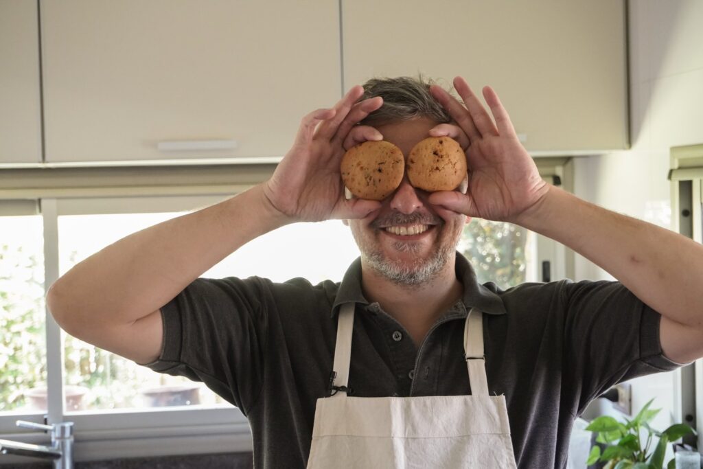 Rami sonríe tapándose los ojos con dos cookies sin gluten