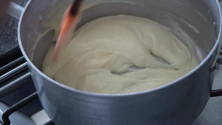 Crema pastelera sin gluten espesa en la olla, mezclada con espátula