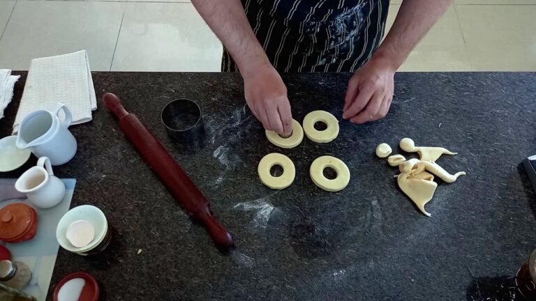Cortando las donas sin gluten con un cortante sobre la masa estirada en la mesada