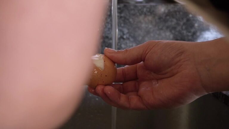 Pelando el huevo apenas cocido para la mayonesa casera pasteurizada