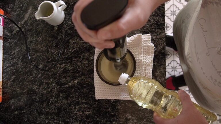 Agregando aceite en hilo mientras se procesa la mayonesa casera con mixer