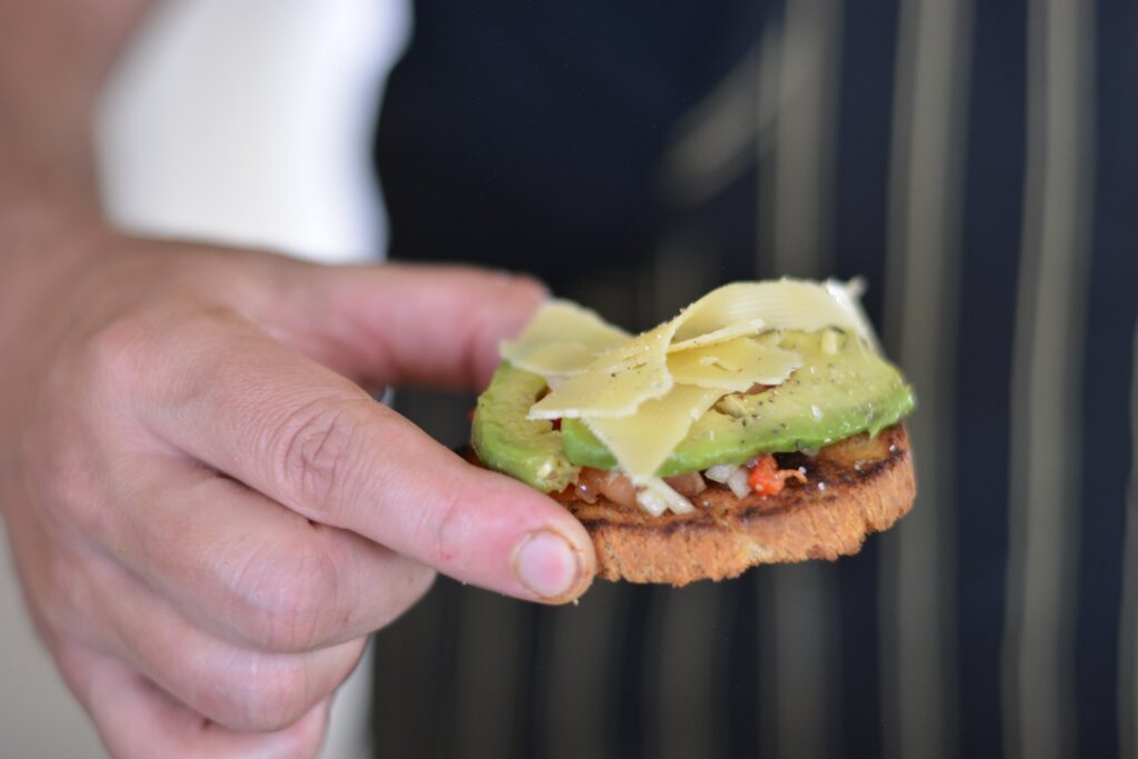 Bruschetta de pan brioche sin gluten tostado con salsa criolla, palta y láminas de queso