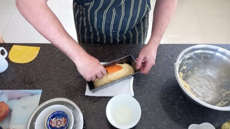 Dando forma a la masa del pan brioche sin gluten dentro del molde con una espátula