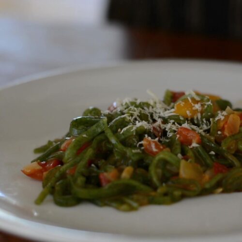 Plato de pasta de espinaca sin gluten con tomates cherry