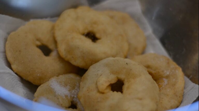 Tortas fritas sin gluten recién fritas con azúcar, escurriendo sobre papel